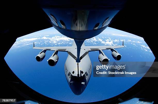 c-17 globemaster receives fuel from a kc-135 stratotanker. - aerial refueling stock-fotos und bilder