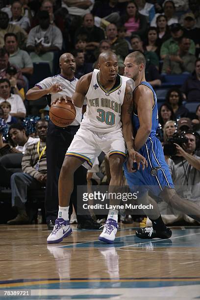 David West of the New Orleans Hornets moves the ball against James Augustine of the Orlando Magic during the game on November 19, 2007 at the New...
