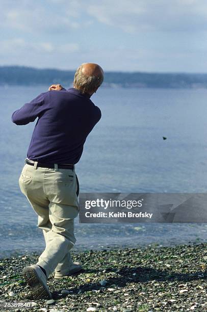 man skipping stones in water - skimming stones stock pictures, royalty-free photos & images