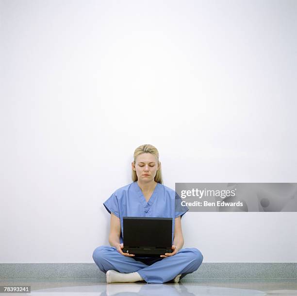 medical professional with a laptop - multitasking nurse stock pictures, royalty-free photos & images