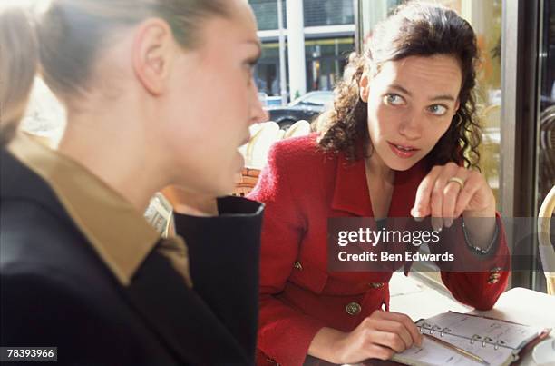 businesswomen talking - peeking stock pictures, royalty-free photos & images