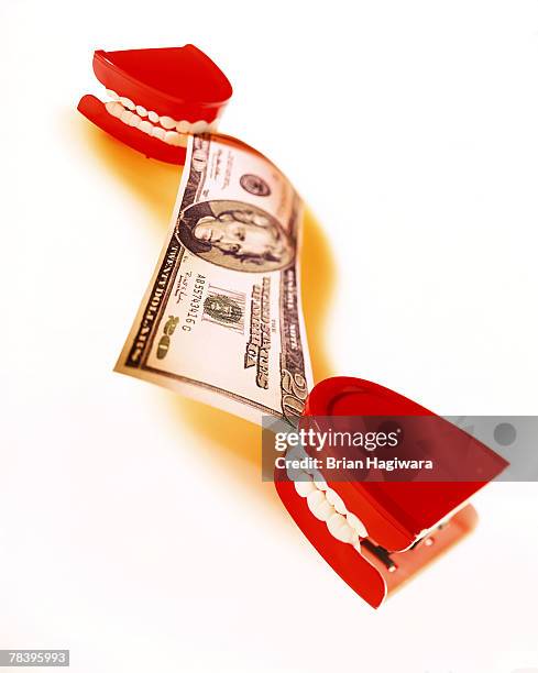 teeth pulling on a twenty dollar bill - clockwork teeth stock pictures, royalty-free photos & images