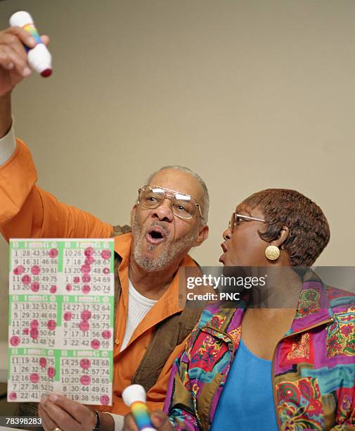 senior couple winning at bingo - bingo card stock-fotos und bilder