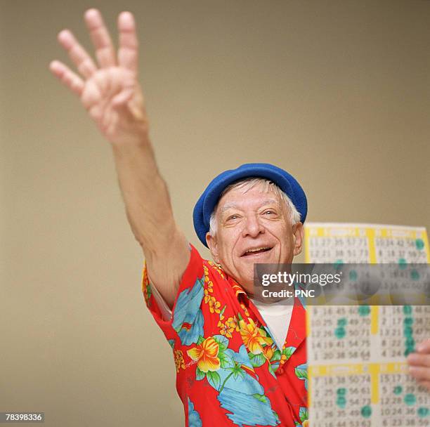 senior man winning at bingo - bingo card stock-fotos und bilder