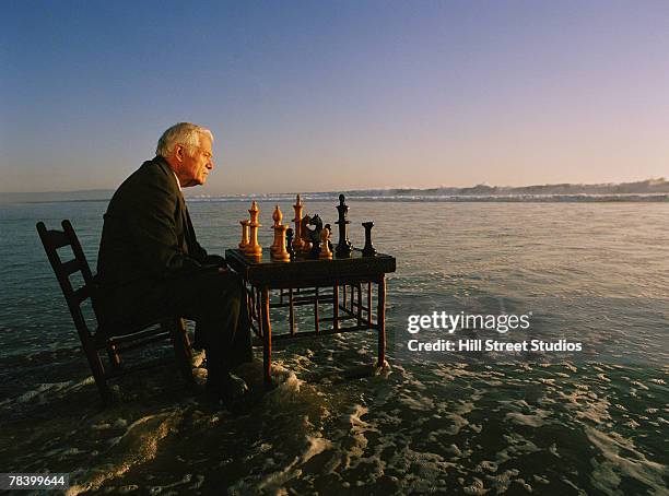 man playing chess on the beach - life si a beach stock pictures, royalty-free photos & images