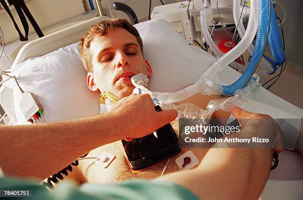 unconscious patient receiving electric shock stimulation - person on ventilator stock pictures, royalty-free photos & images