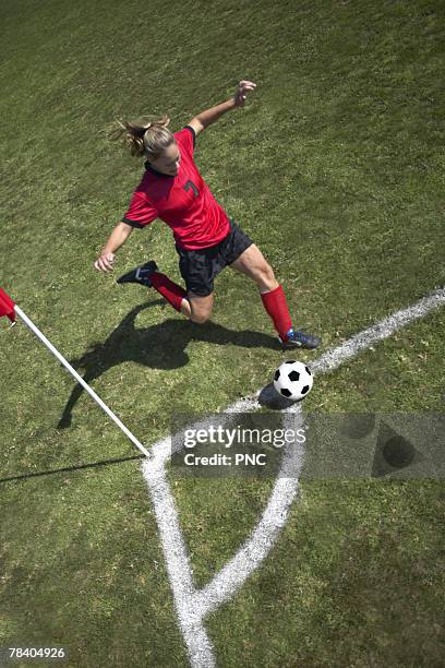 woman kicking soccer ball - corner kick stock-fotos und bilder