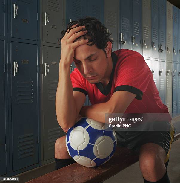 upset soccer player in locker room - locker room ストックフォトと画像