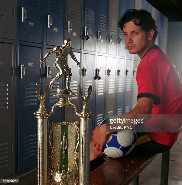 soccer player in locker room with trophy - locker room ストックフォトと画像