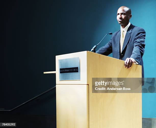 public speaker at podium - rate announcement news conference stockfoto's en -beelden