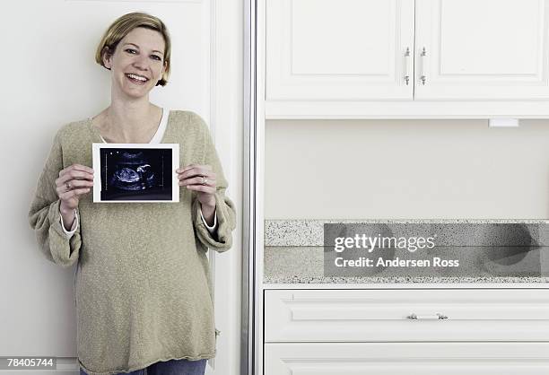 pregnant woman holding sonogram - wissenschaftliche bildtechnik stock-fotos und bilder