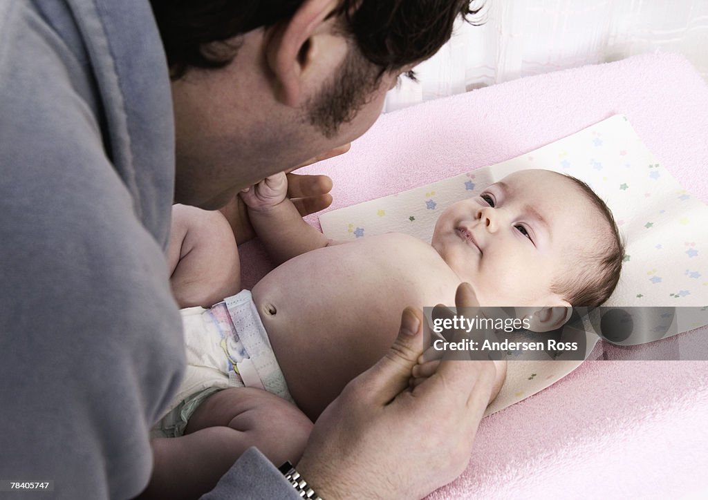 Father with baby on changing table