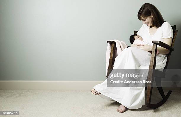 mother and baby in rocking chair - balancearse fotografías e imágenes de stock