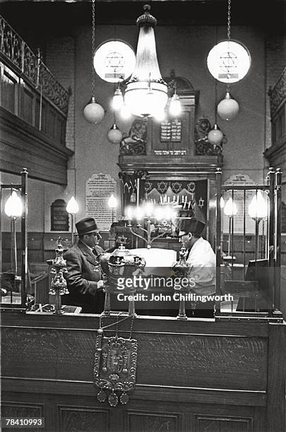 The interior of Princelet Street Synagogue in London's Whitechapel, 12th April 1952. The First Reader of the synagogue is on the right. Original...