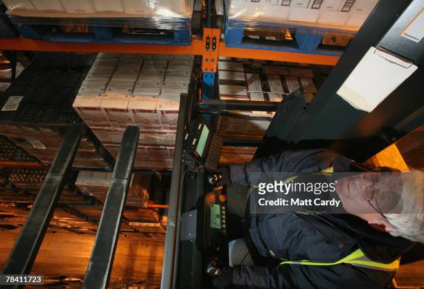 Fork lift crane driver Steve Stiley reaches for a pallet on the top of a rack at the giant distribution centre in Avonmouth on December 12 2007 near...