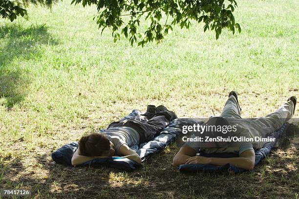 campers lying on top of sleeping bags - man sleeping with cap stock pictures, royalty-free photos & images