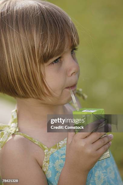 girl sipping from juice box - boisson en brique photos et images de collection