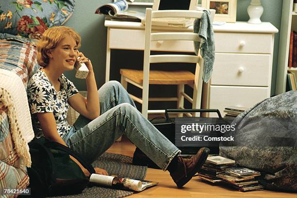 girl sitting on bedroom floor and talking on telephone - 1990 fotografías e imágenes de stock