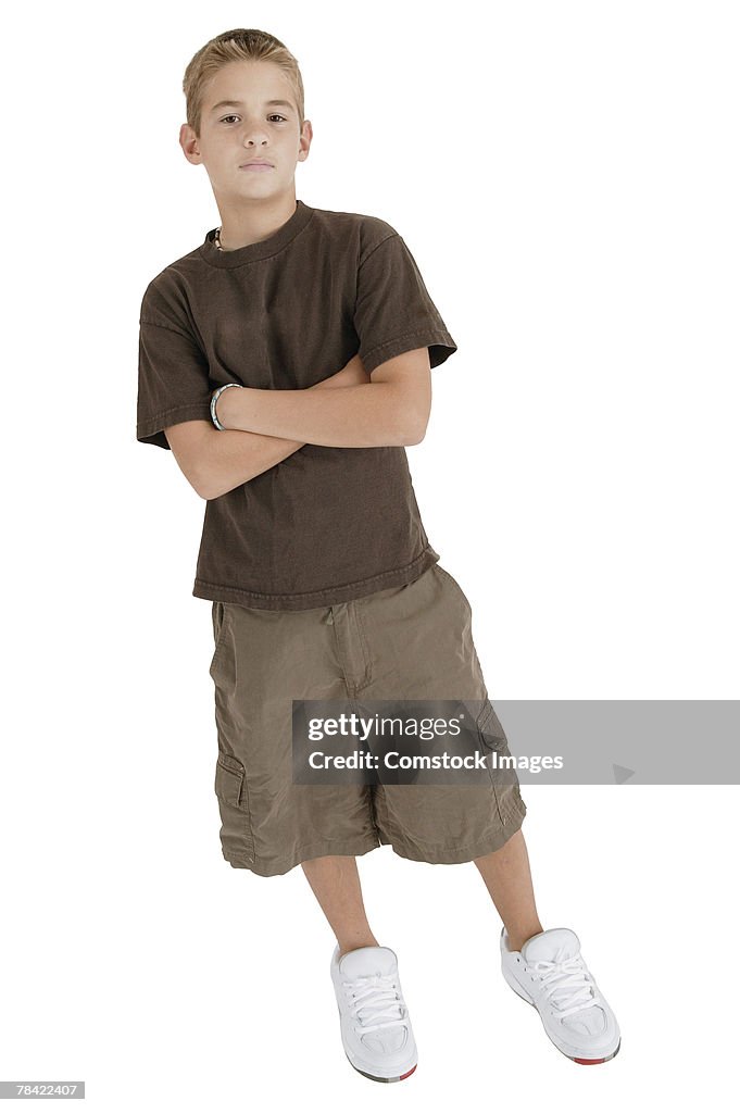 Teenage boy standing with arms crossed