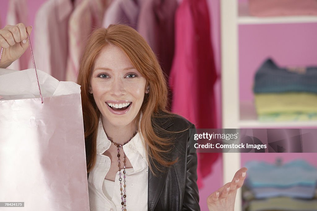 Excited woman in clothing store with shopping bag