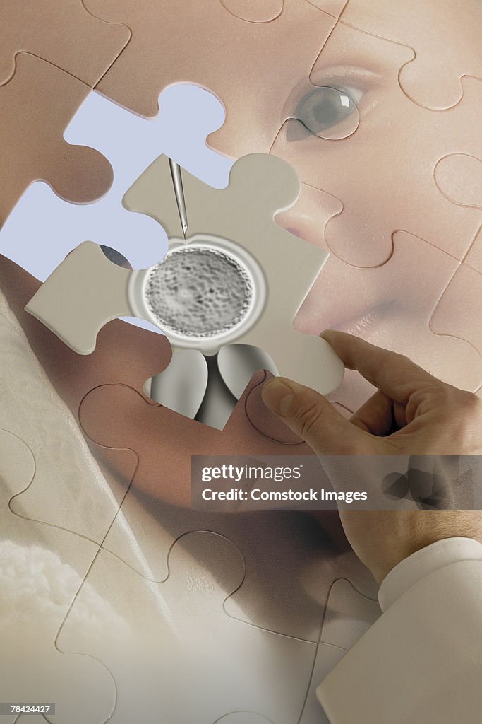 Hand placing in vitro fertilization piece onto baby puzzle