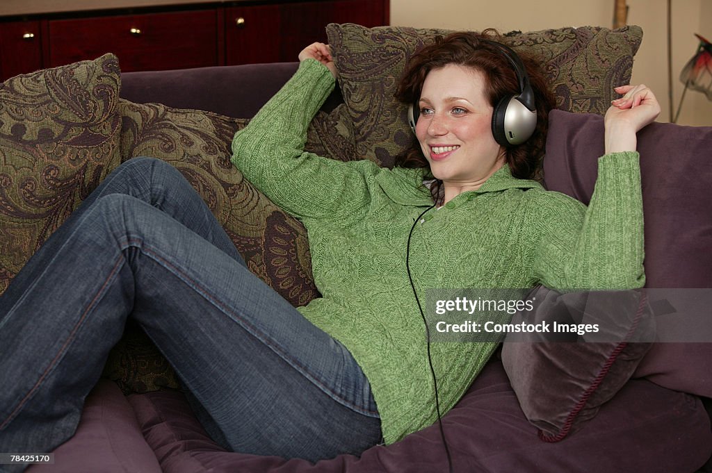 Woman relaxing on couch listening to music