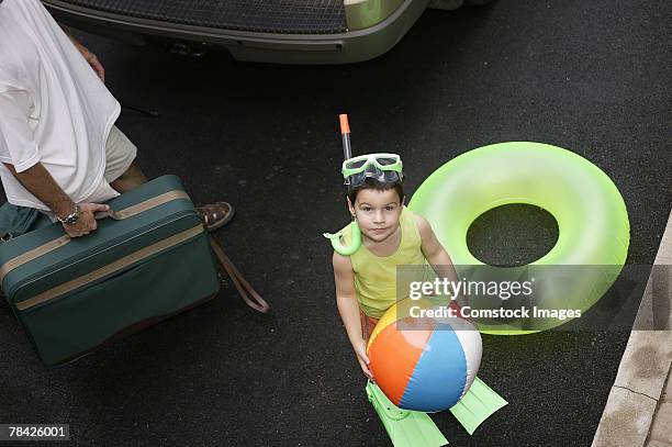 boy holding beach ball , going on vacation - zwemvliezen stockfoto's en -beelden