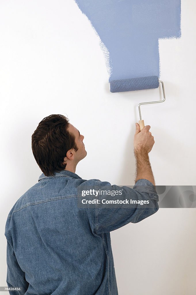 Man painting wall with roller
