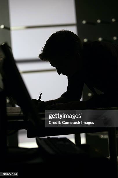 dark silhouette of man working - contraluz fotografías e imágenes de stock