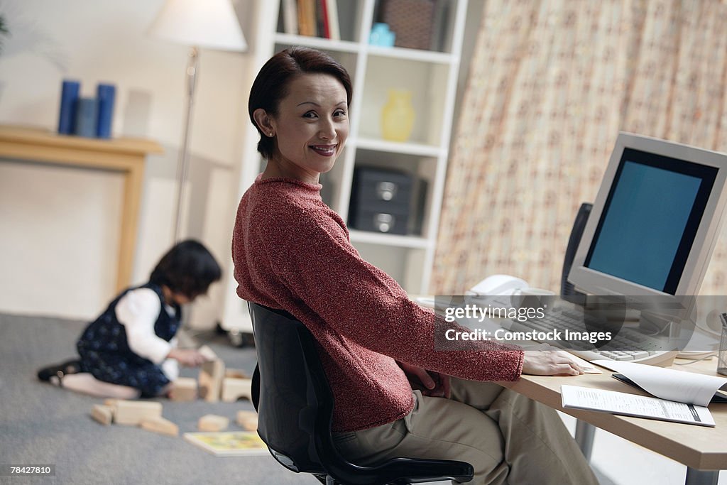 Woman sitting at computer in home