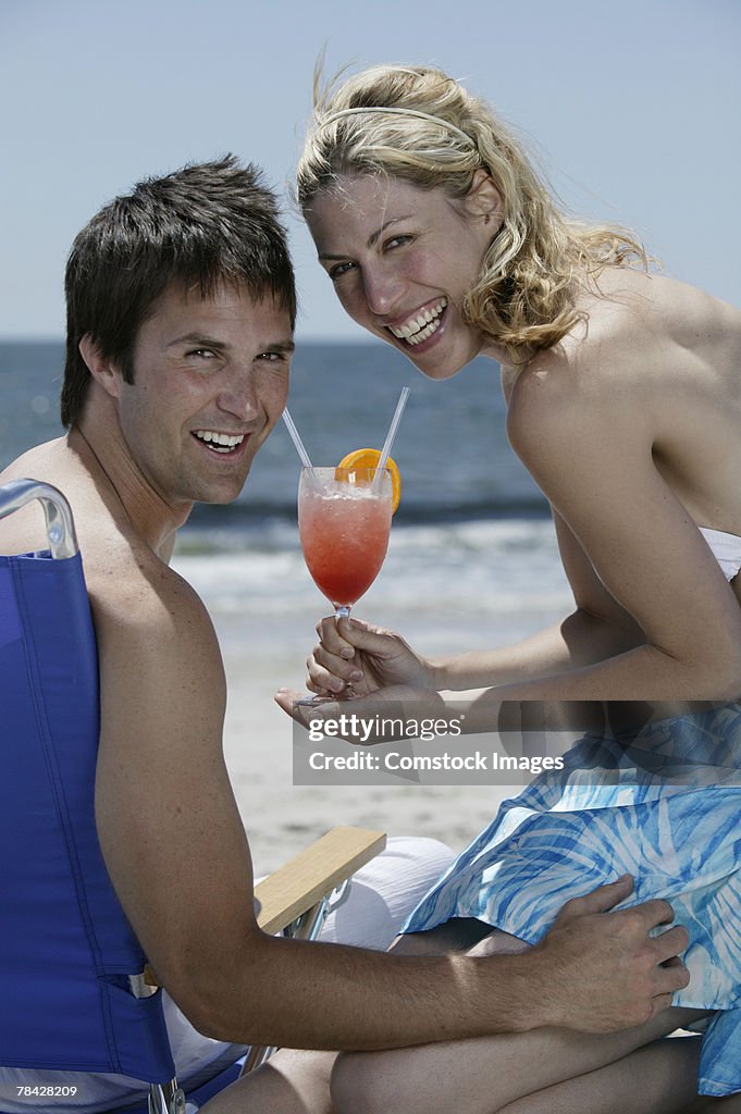 Couple with tropical drink on beach