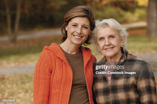 mother and adult daughter posing outdoors in autumn - season 42 stock pictures, royalty-free photos & images