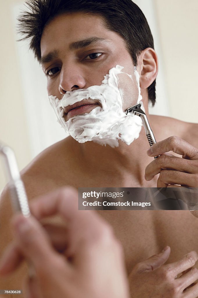 Man shaving in mirror