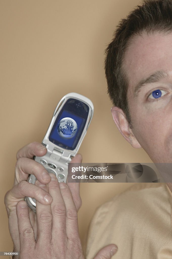 Man holding cell phone with picture of globe