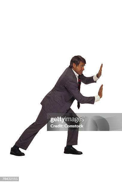 businessman pushing against something - bookend foto e immagini stock