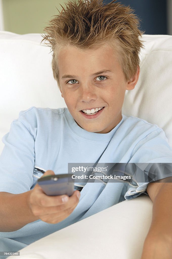 Boy holding television remote control