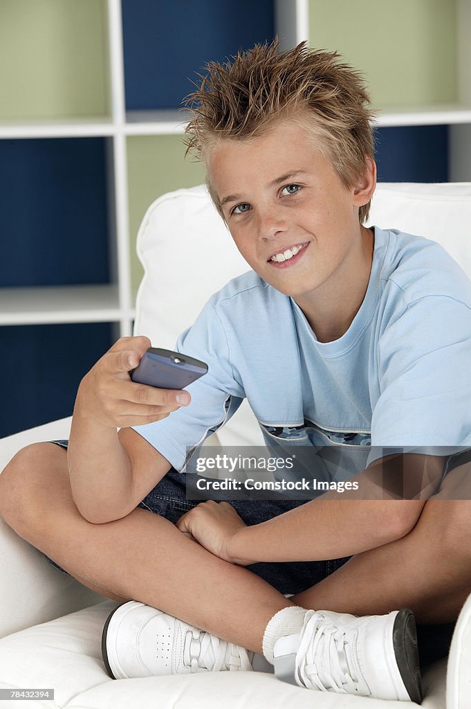 Boy holding television remote control