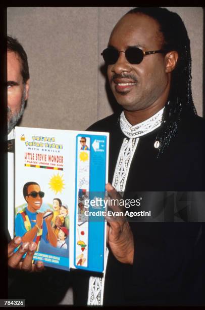 Stevie Wonder holds his book "Little Stevie Wonder in Places Under the Sun" June 25, 1996 in New York City. The American Foundation for the Blind...