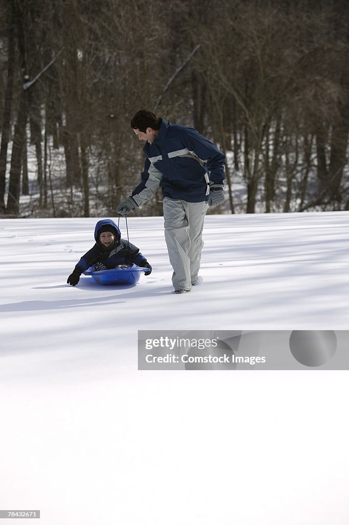Father and son with a sled