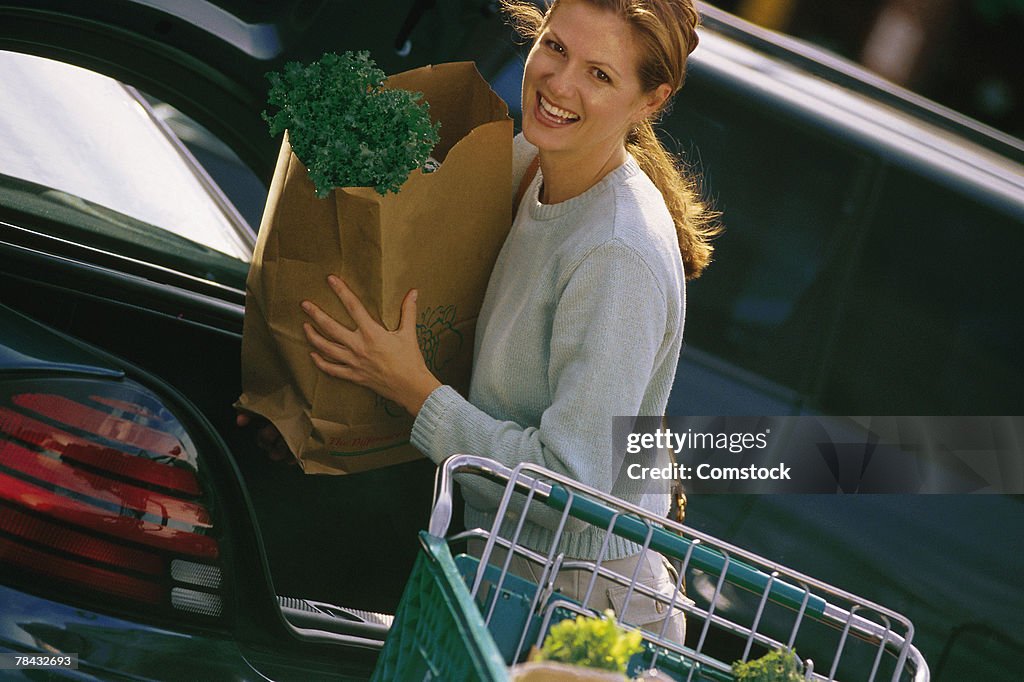 Woman loading groceries into car