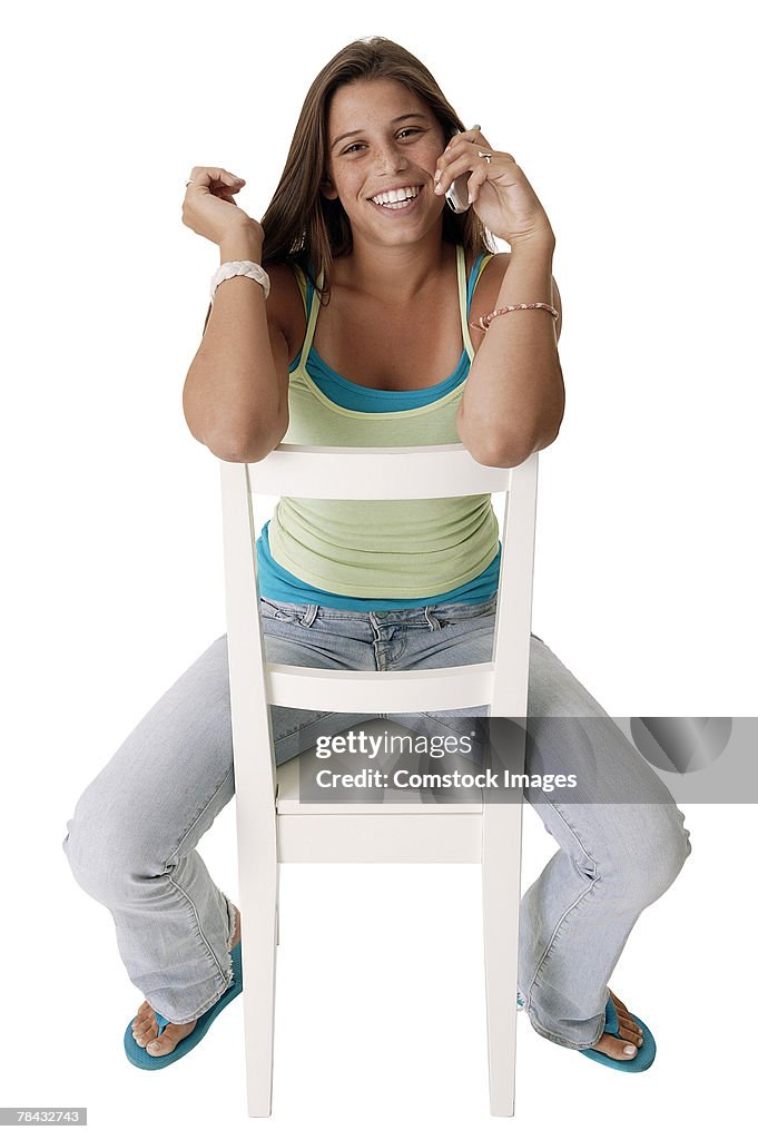 Teenage girl in chair talking on cell phone