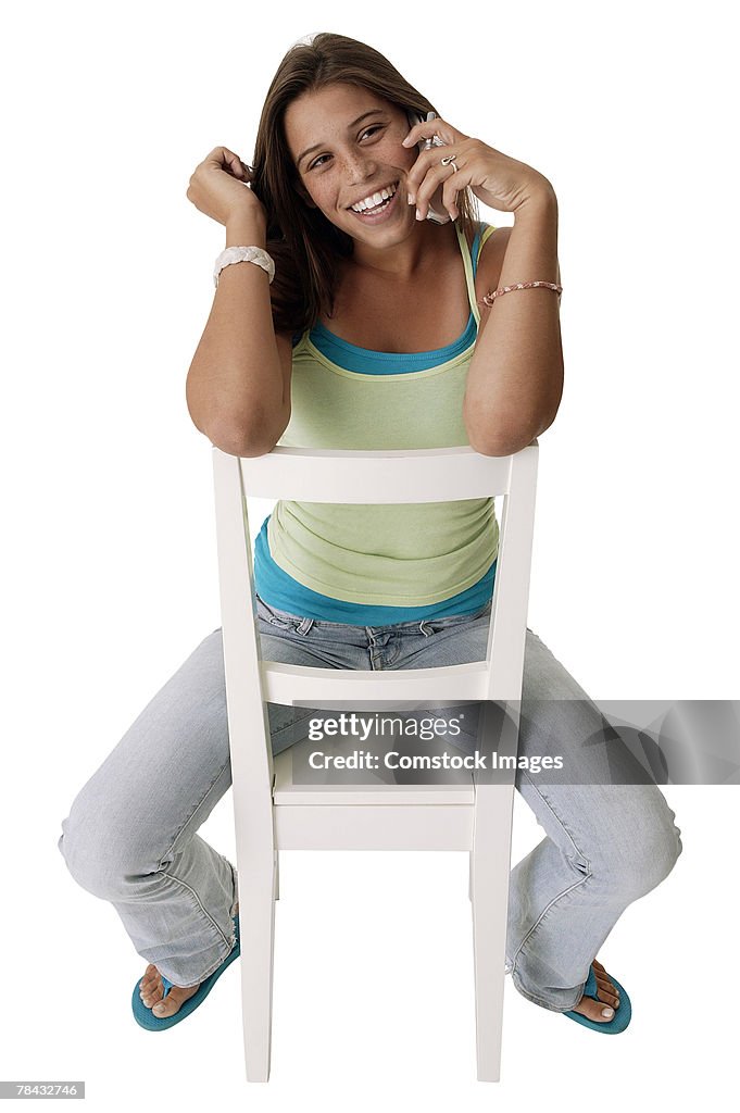 Teenager in chair talking on cell phone