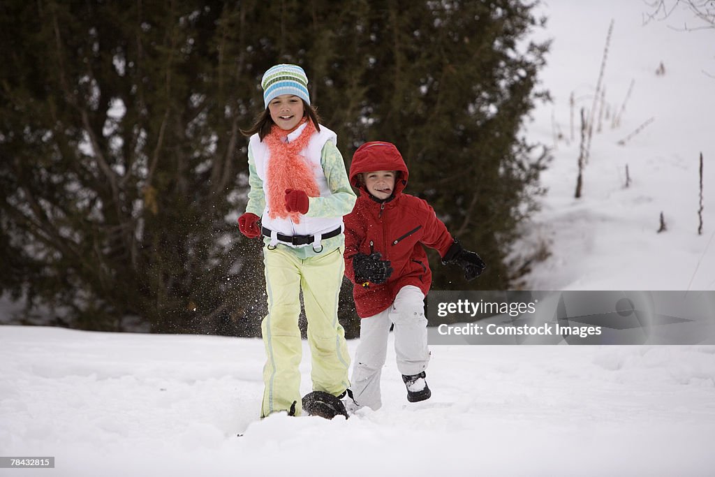 Brother and sister playing in the snow