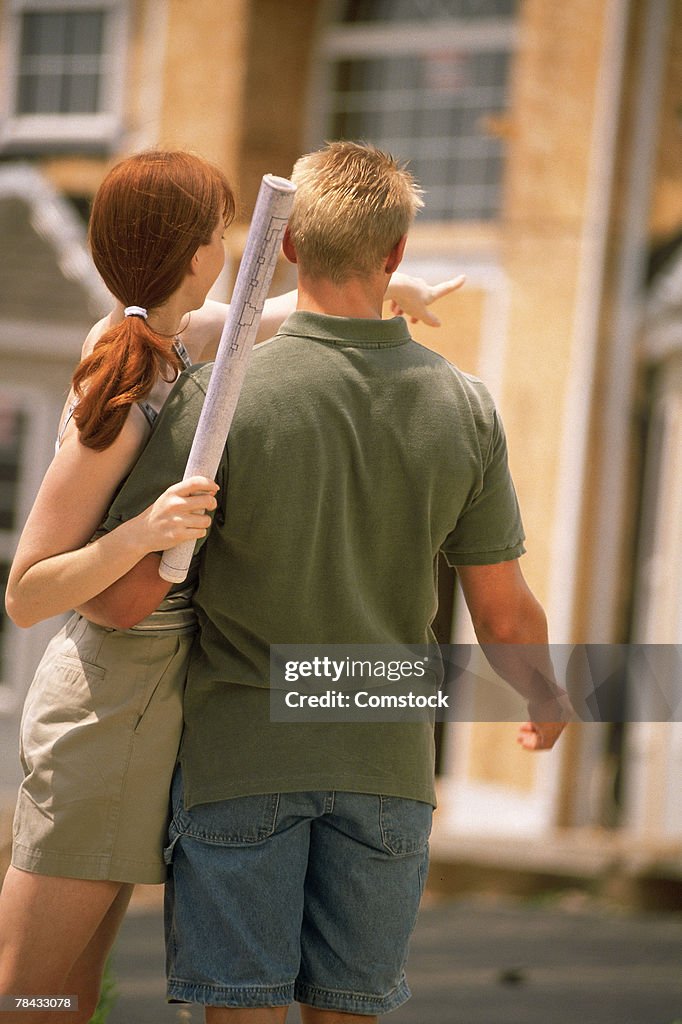Couple looking at home being built