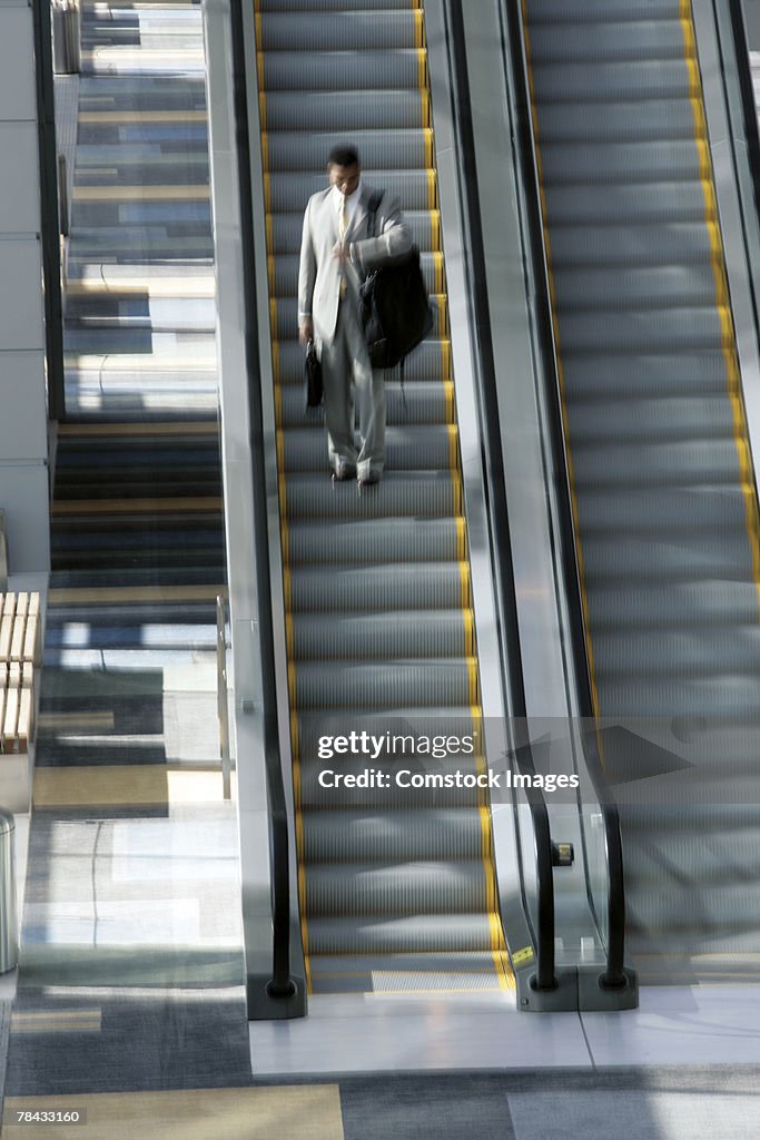 Man on escalator with luggage