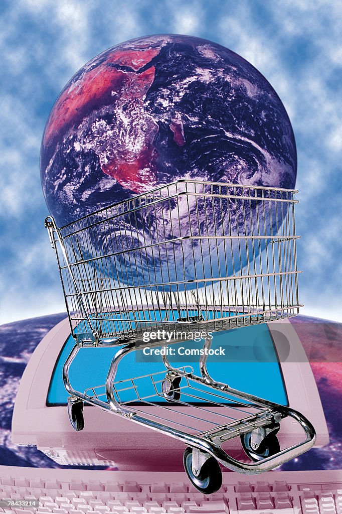Earth in shopping cart on top of image of computer on Earth