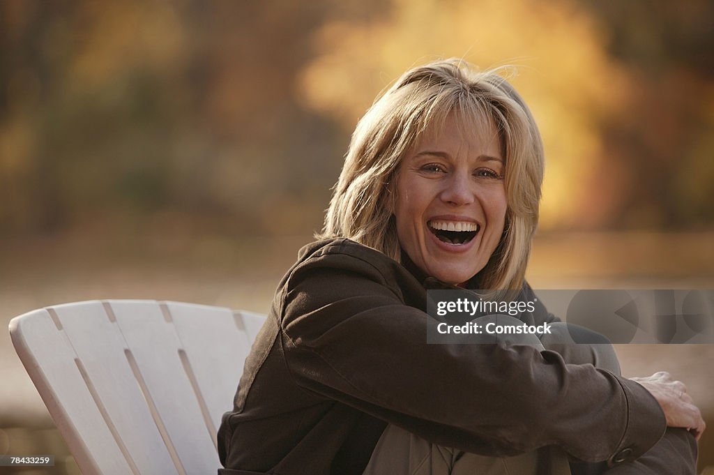 Woman sitting in chair outdoors laughing