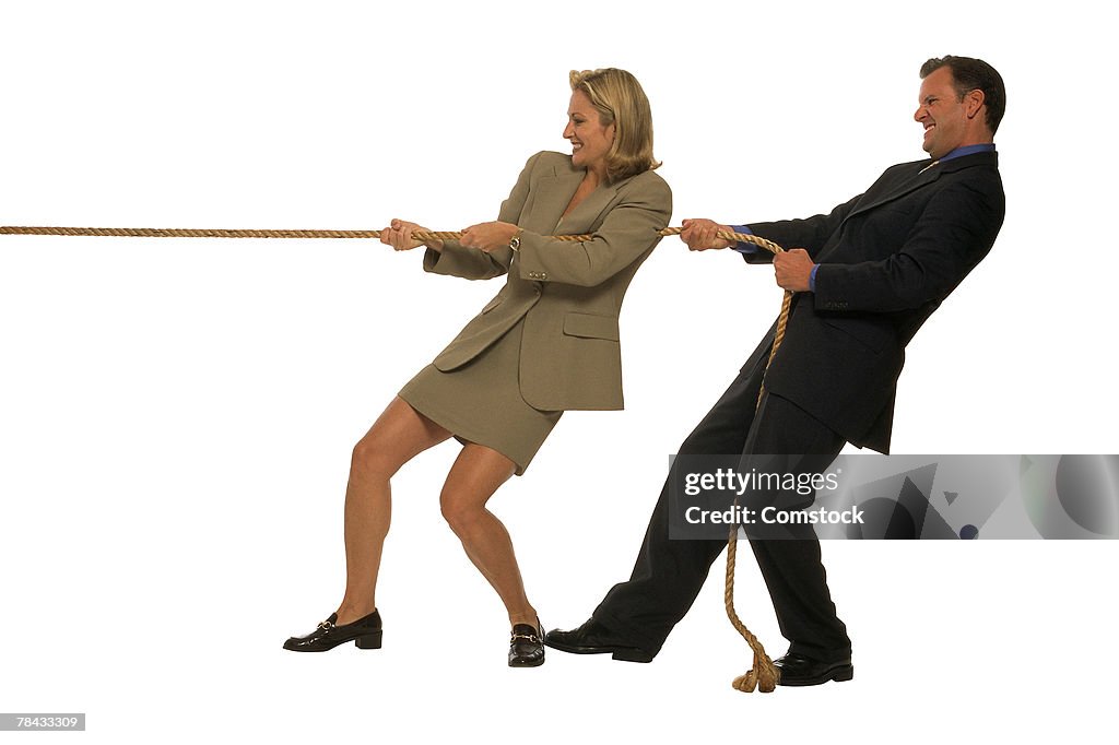 Businessman and woman tugging on rope