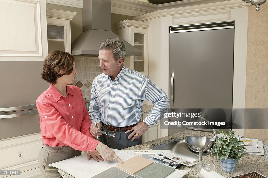 Man and woman in kitchen with tile samples