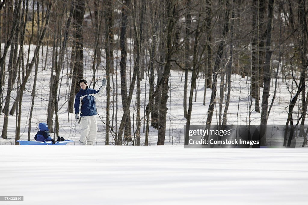 Father pulling son on sled